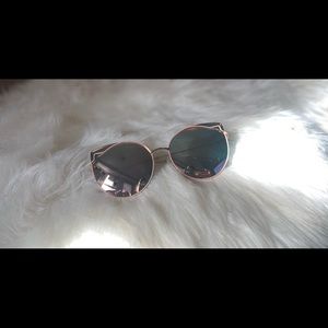 Mirror Cat eye style sun glasses gold frame and light pink accents.